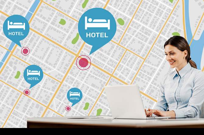 A woman sitting at the desk is using her PC to manage hotel TVs across different locations.